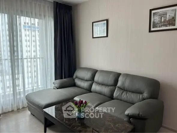 Modern living room with gray sofa and marble coffee table, featuring elegant decor and natural light.
