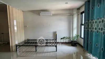 Spacious bedroom with air conditioning and large window, featuring a metal bed frame and elegant curtains.