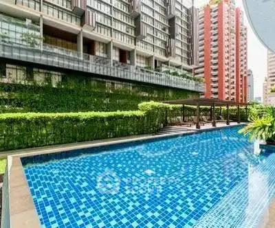 Luxurious residential building with a stunning outdoor pool and lush greenery.