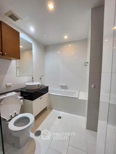 Modern bathroom with sleek fixtures and bathtub in a contemporary apartment.