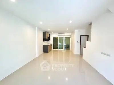 Spacious modern living room with open kitchen layout and glossy tiled floors