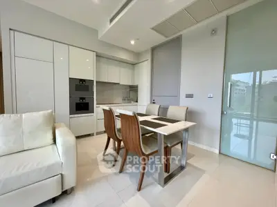 Modern kitchen with sleek dining area and built-in appliances in a stylish apartment.
