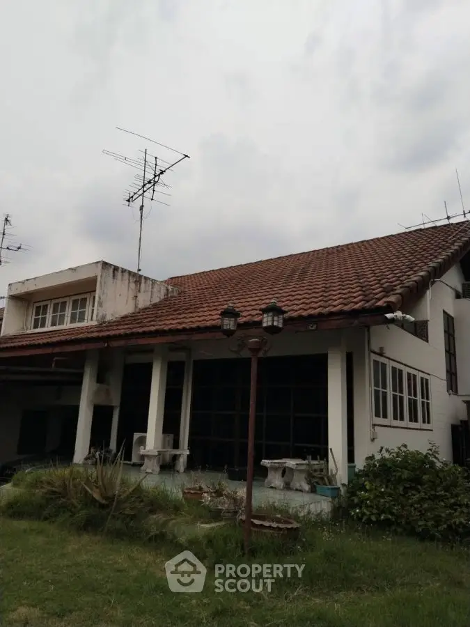 Charming suburban house with red tile roof and lush garden