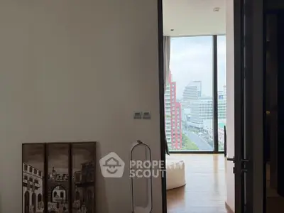 Modern apartment with floor-to-ceiling windows offering stunning city views, elegant decor, and natural light.