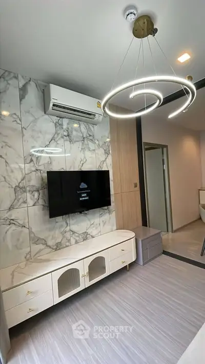Modern living room with stylish lighting and marble accent wall, featuring a sleek TV setup and elegant furniture.