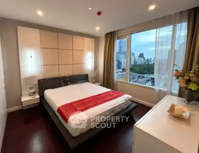 Luxurious bedroom with city view, modern decor, and elegant furnishings in high-rise apartment.
