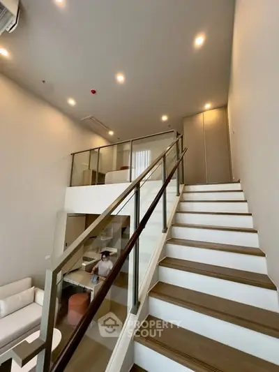 Modern duplex interior with stylish staircase and cozy living area