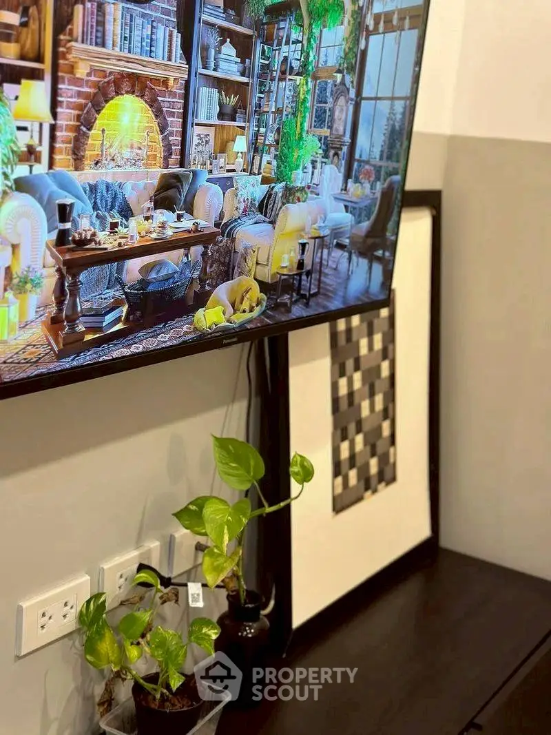 Stylish living room with wall-mounted TV and indoor plants, perfect for modern living.