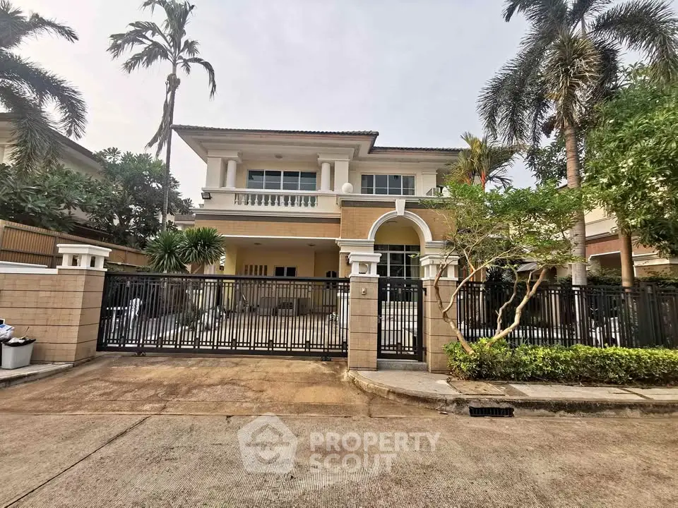 Stunning two-story villa with lush garden and gated entrance in tropical setting.