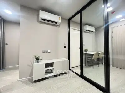 Modern apartment interior with mirrored closet and air conditioning, featuring sleek furniture and neutral tones.