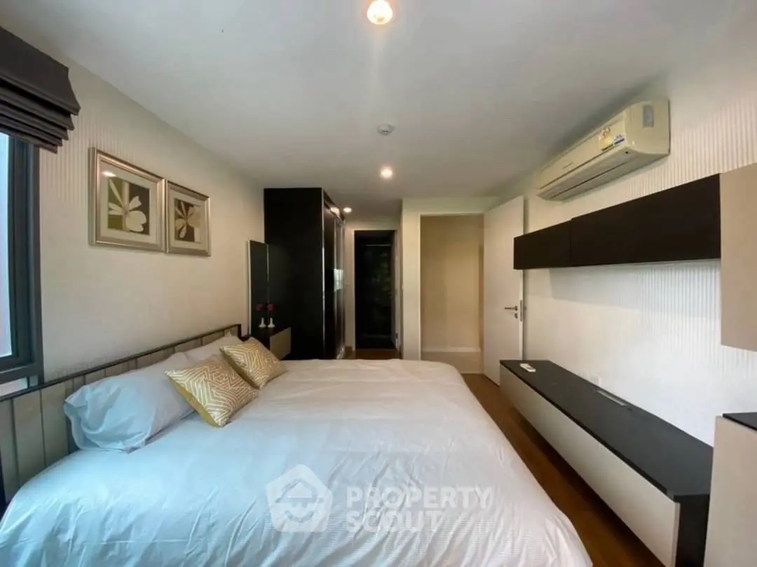 Modern bedroom with stylish decor and air conditioning in a cozy apartment.