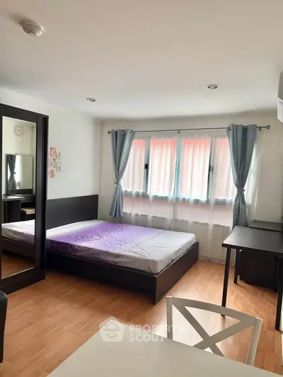 Spacious bedroom with large windows and modern furnishings