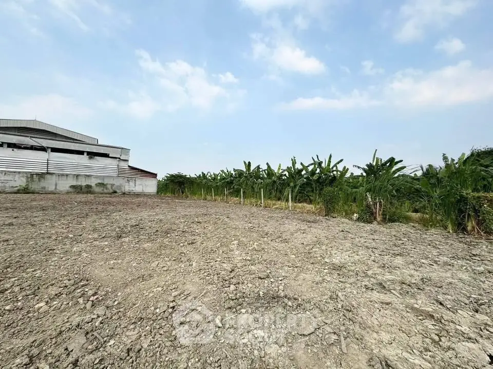 Expansive land plot with lush greenery and clear skies, ideal for development opportunities.
