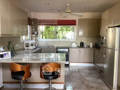 Spacious kitchen with modern appliances and breakfast bar seating in a stylish home.
