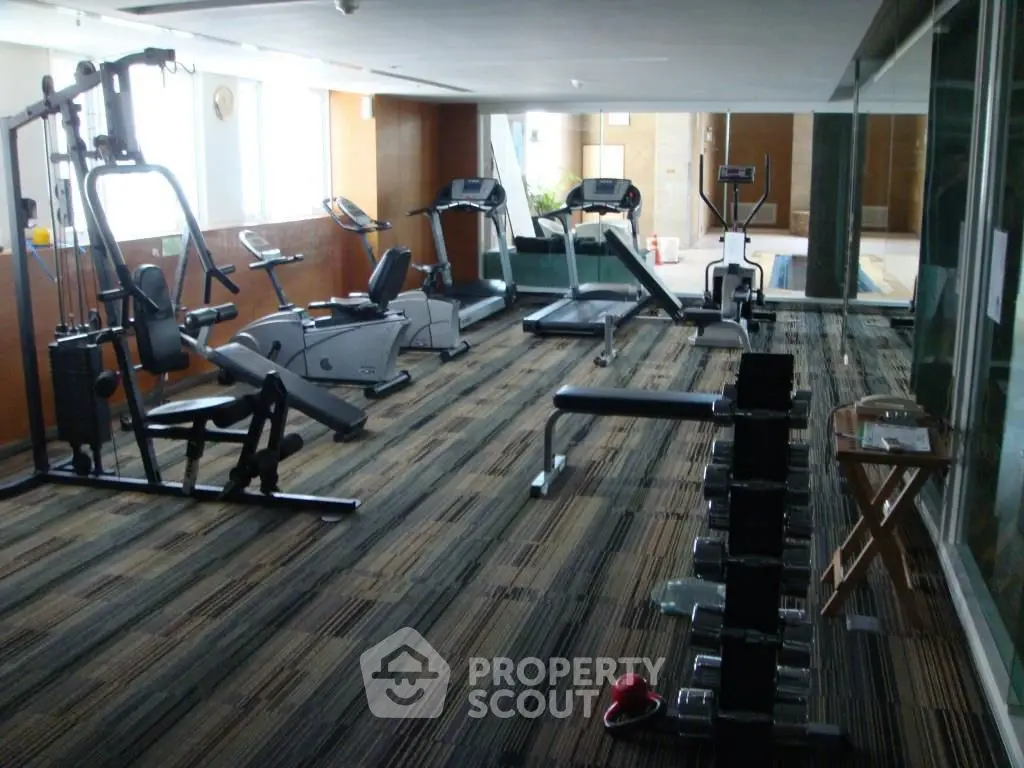 Spacious gym with modern fitness equipment in luxury residential building