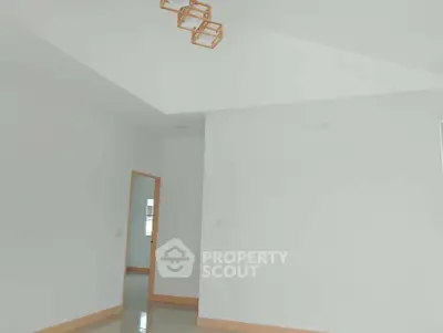 Spacious minimalist interior with modern lighting and neutral tones.