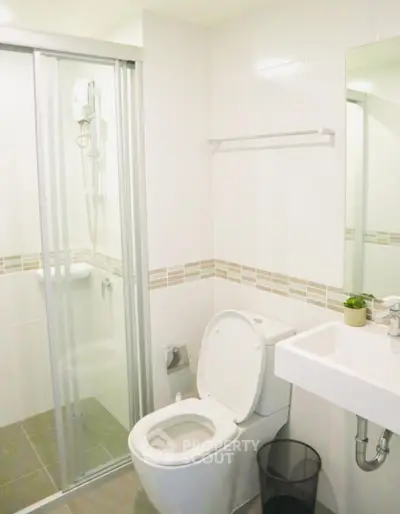 Modern bathroom with glass shower and sleek fixtures in a contemporary apartment.
