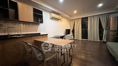 Modern open-layout kitchen and dining area with sleek design and wooden flooring.