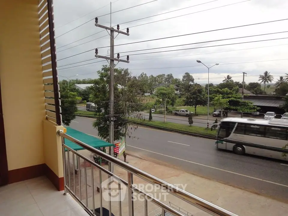 Spacious balcony with scenic road view and lush greenery, perfect for relaxation.