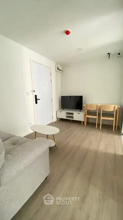 Modern living room with sleek furniture and TV setup, perfect for relaxation.