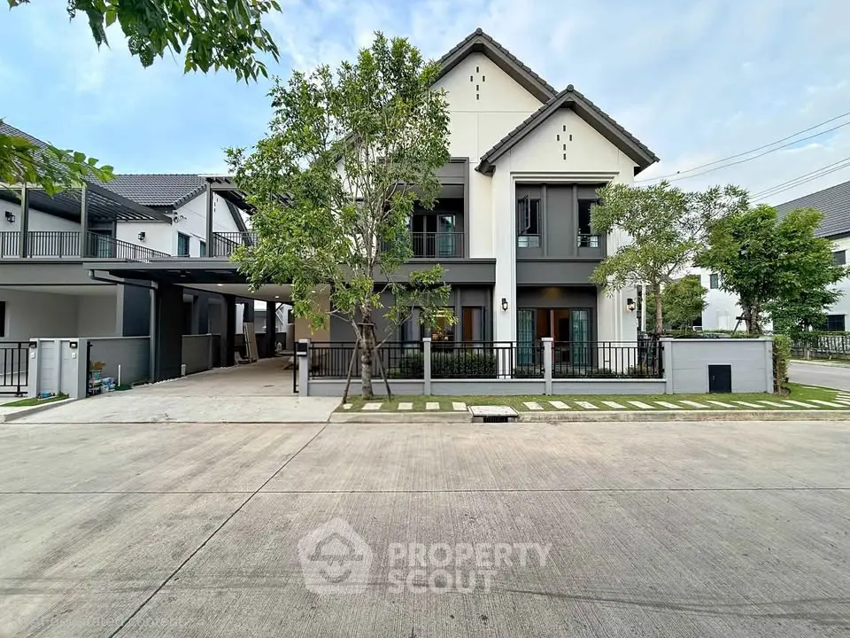 Modern two-story house with sleek design and spacious driveway in a serene neighborhood.