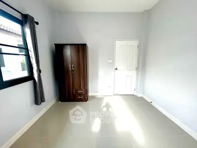 Bright empty room with wardrobe and window, ideal for customization in a modern home.