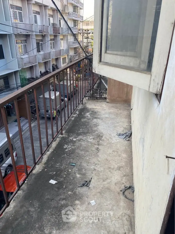 Urban balcony with street view in residential area, potential for renovation and personalization.