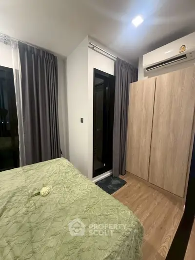 Cozy bedroom with modern decor, featuring a large wardrobe and air conditioning, perfect for comfortable living.