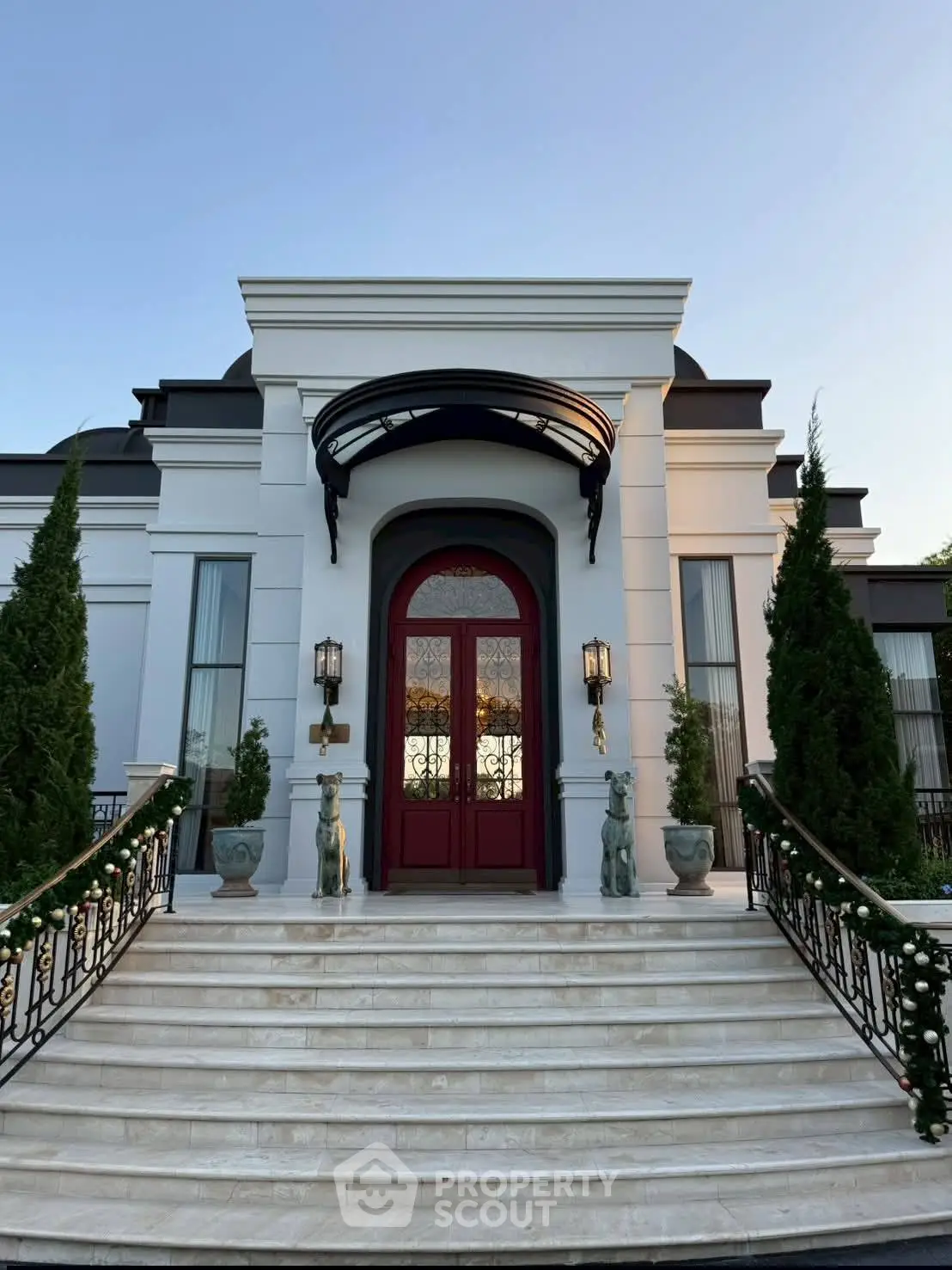 Luxurious mansion entrance with grand staircase and elegant landscaping