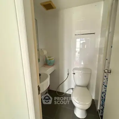 Compact bathroom with modern fixtures and tiled flooring in a cozy apartment.