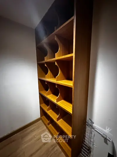 Spacious wooden storage unit with multiple shelves in a modern interior.