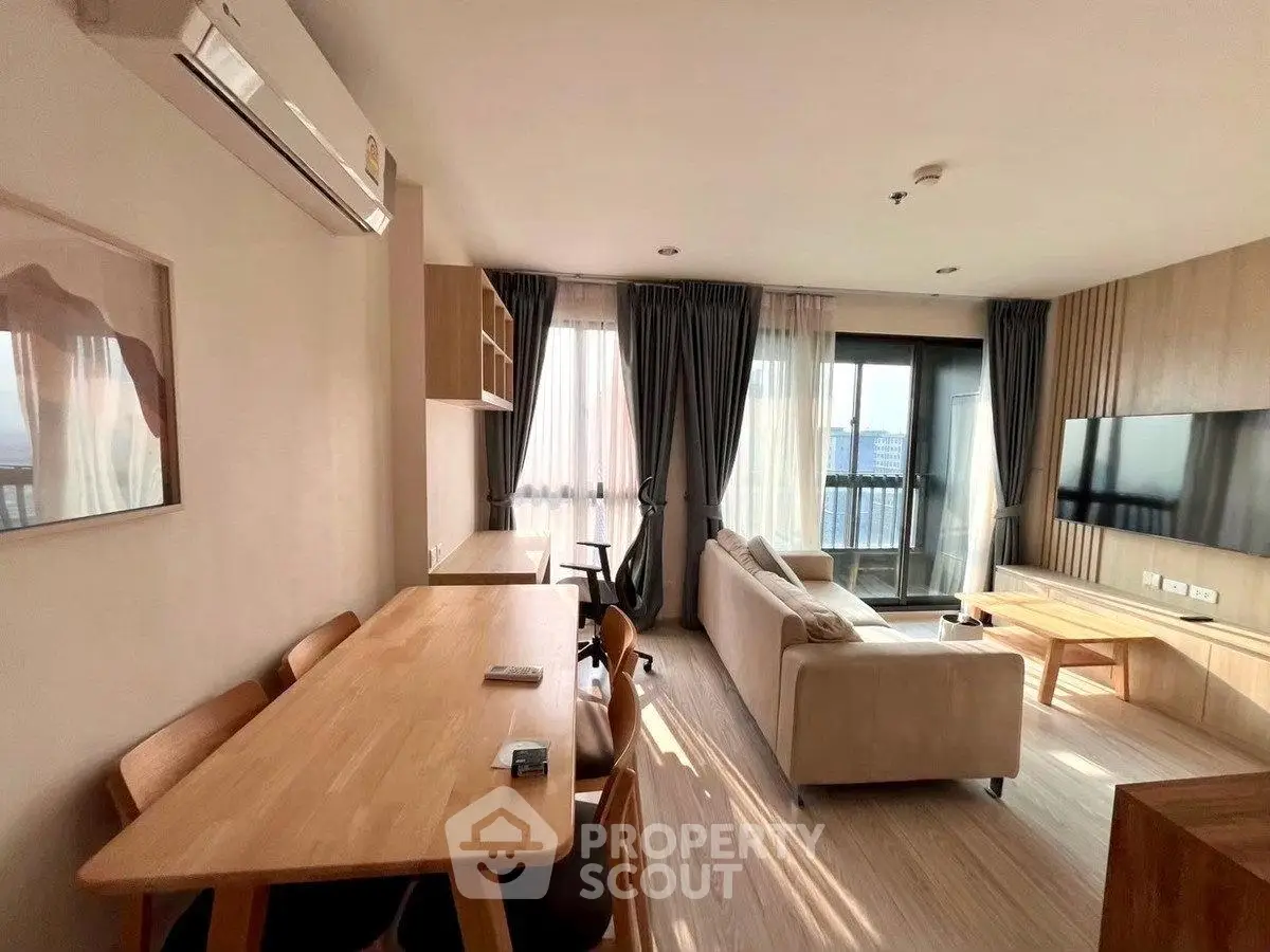 Modern living room with large windows and stylish furniture, offering a cozy and inviting atmosphere.