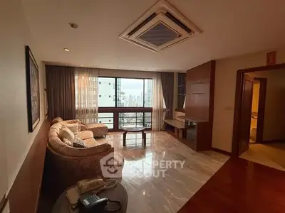 Spacious living room with city view, elegant sofa, and marble flooring in modern apartment.