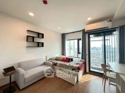 Modern bedroom with city view, featuring cozy sofa, stylish shelves, and spacious balcony access.