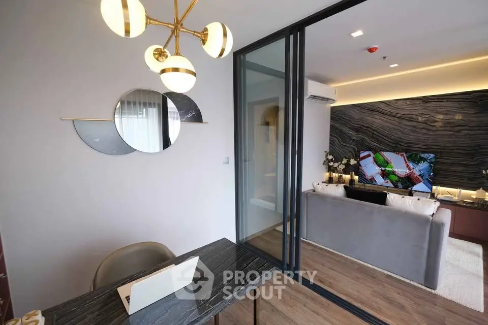 Modern living room with stylish decor and open layout, featuring a sleek desk and elegant lighting.