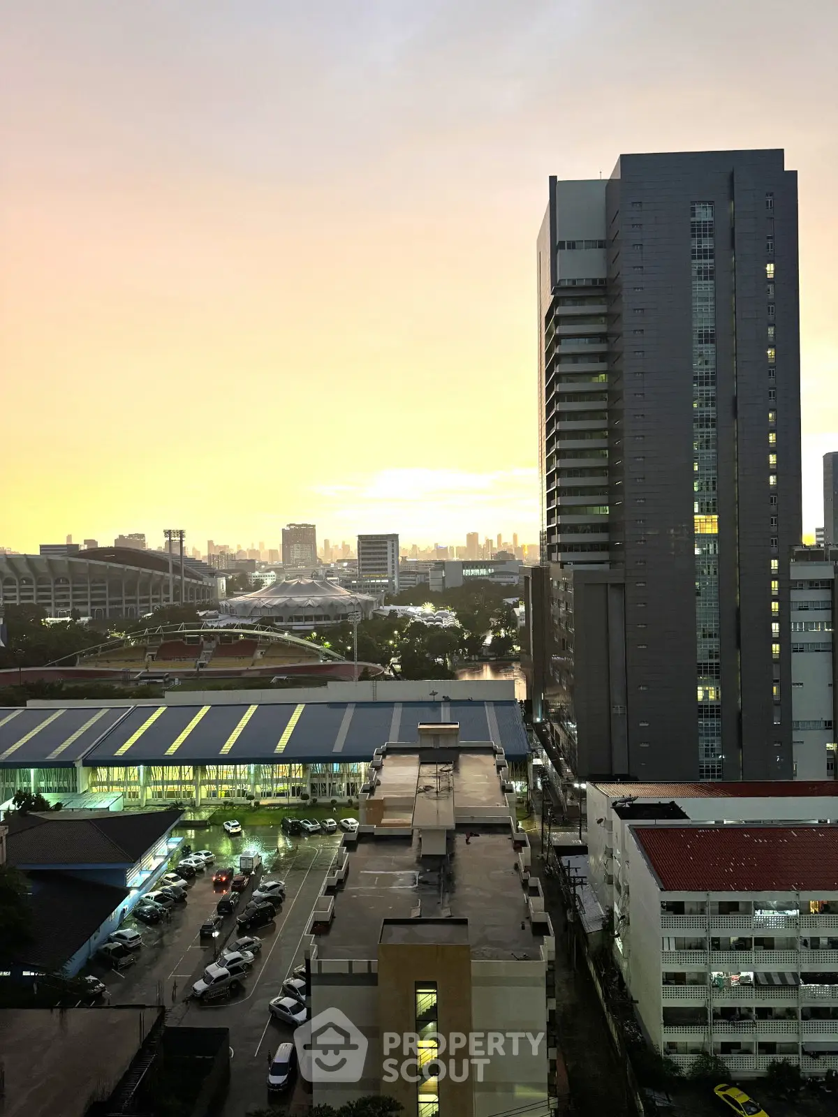 Stunning cityscape view from high-rise building at sunset, showcasing urban skyline and vibrant evening sky.