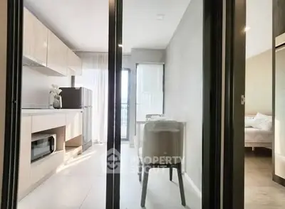 Modern kitchen with sleek cabinetry and dining area in bright apartment