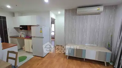 Modern apartment interior with open kitchen and stylish living area featuring wooden flooring and air conditioning.