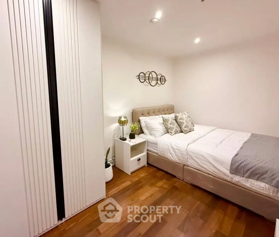 Cozy modern bedroom with stylish decor and wooden flooring