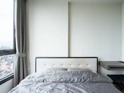 Modern bedroom with city view, featuring a stylish bed and elegant curtains.