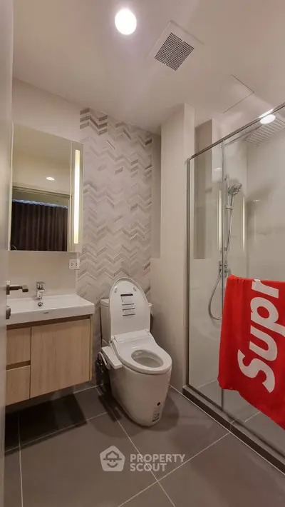 Modern bathroom with sleek design, featuring a glass shower and stylish vanity.