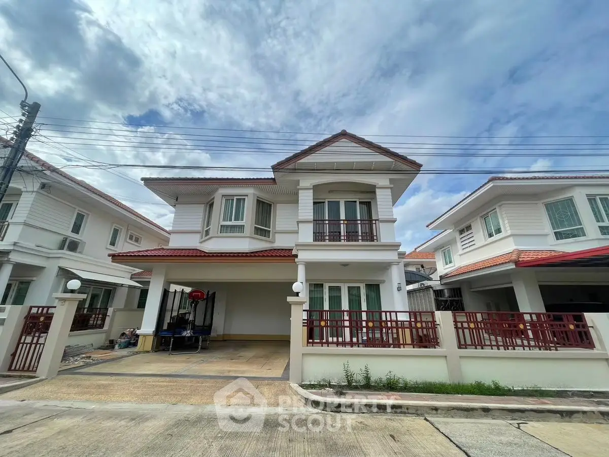 Charming two-story house with red roof and spacious driveway in a serene neighborhood.