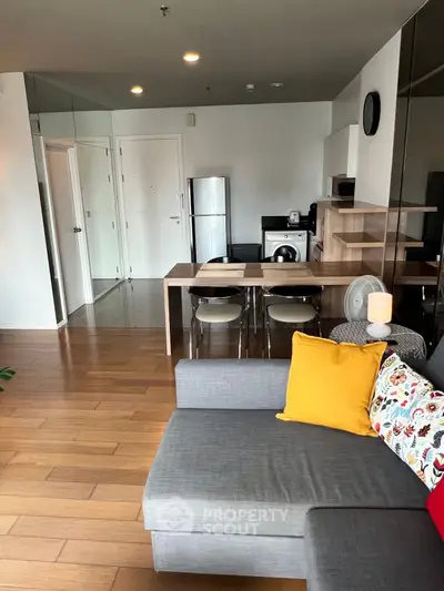 Modern living room with stylish decor and open kitchen layout, featuring hardwood floors and cozy seating area.