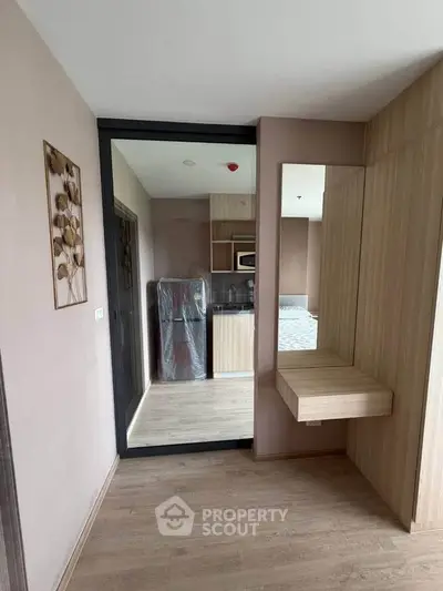 Modern apartment interior with wooden flooring and stylish decor, featuring a compact kitchen and cozy living space.