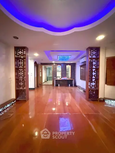 Spacious living room with elegant lighting and wooden flooring