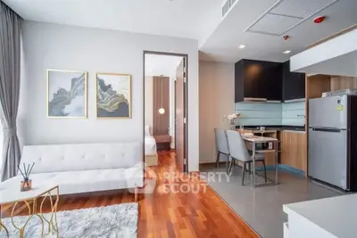 Modern open-plan living room and kitchen with elegant decor and hardwood floors