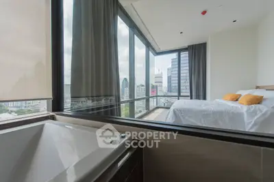 Luxurious bedroom with stunning city view and modern bathtub in high-rise apartment.