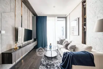 Modern living room with sleek design, large TV, and elegant decor in a high-rise apartment.