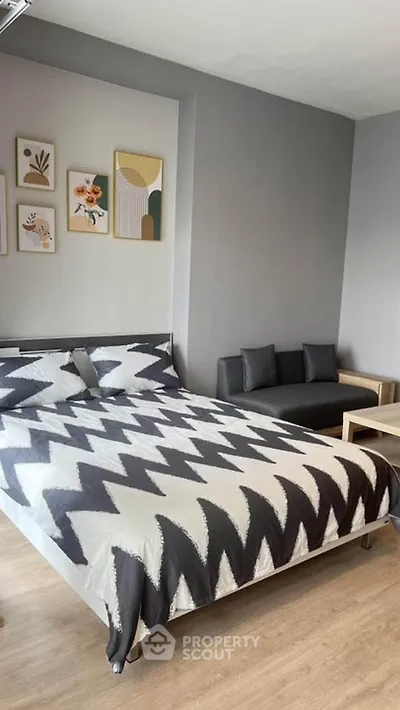 Modern bedroom with stylish decor and cozy seating area, perfect for relaxation.