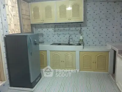 Charming kitchen with vintage cabinets and modern fridge, perfect for cozy home cooking.